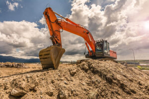 Orange excavator on dirt mound