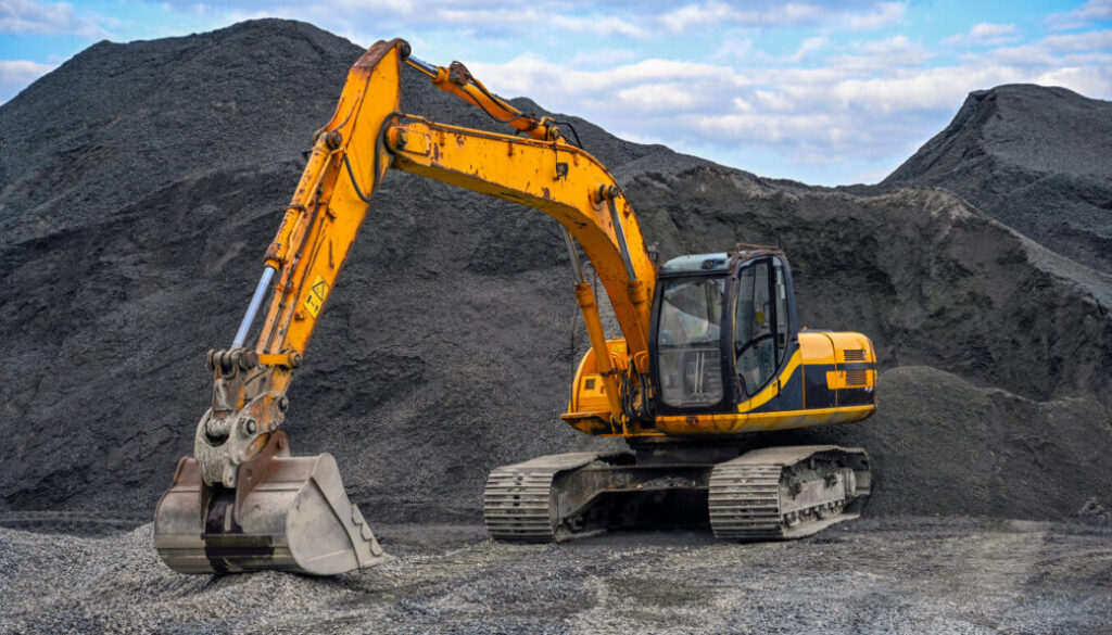 Yellow excavator on gravel site