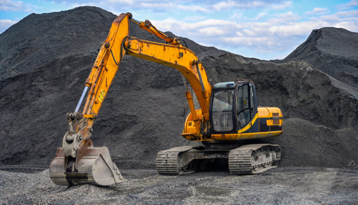 Yellow excavator on gravel site