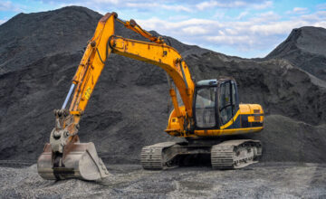 Yellow excavator on gravel site