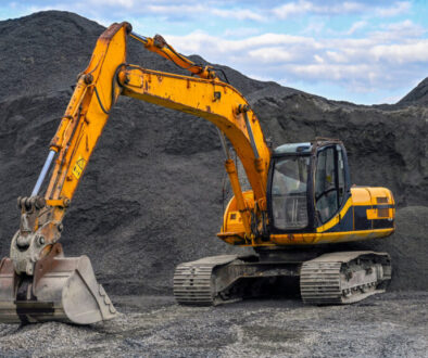 Yellow excavator on gravel site