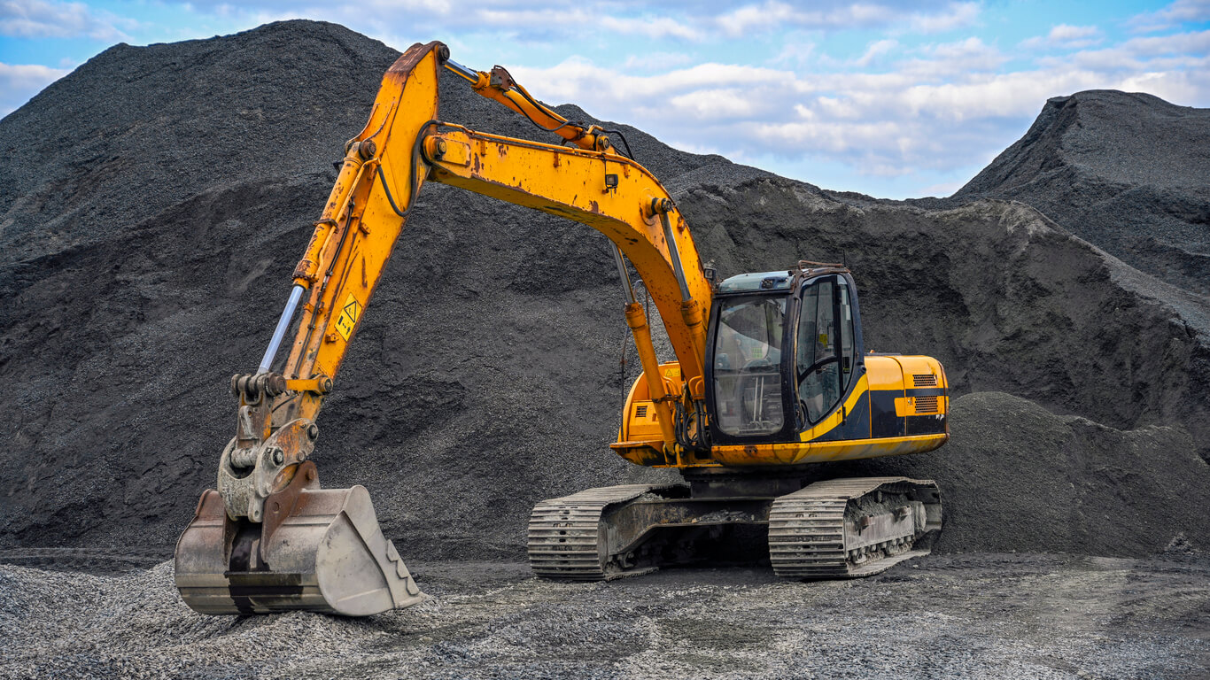 Yellow excavator on gravel site