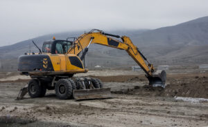 What Is an Excavator? Key Facts, Popular Models, and Buying Tips 2 yellow wheeled excavator in fog