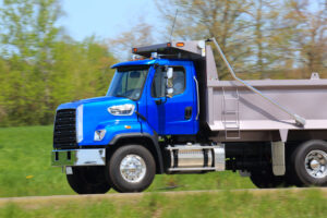 Vibrant blue dump truck on road