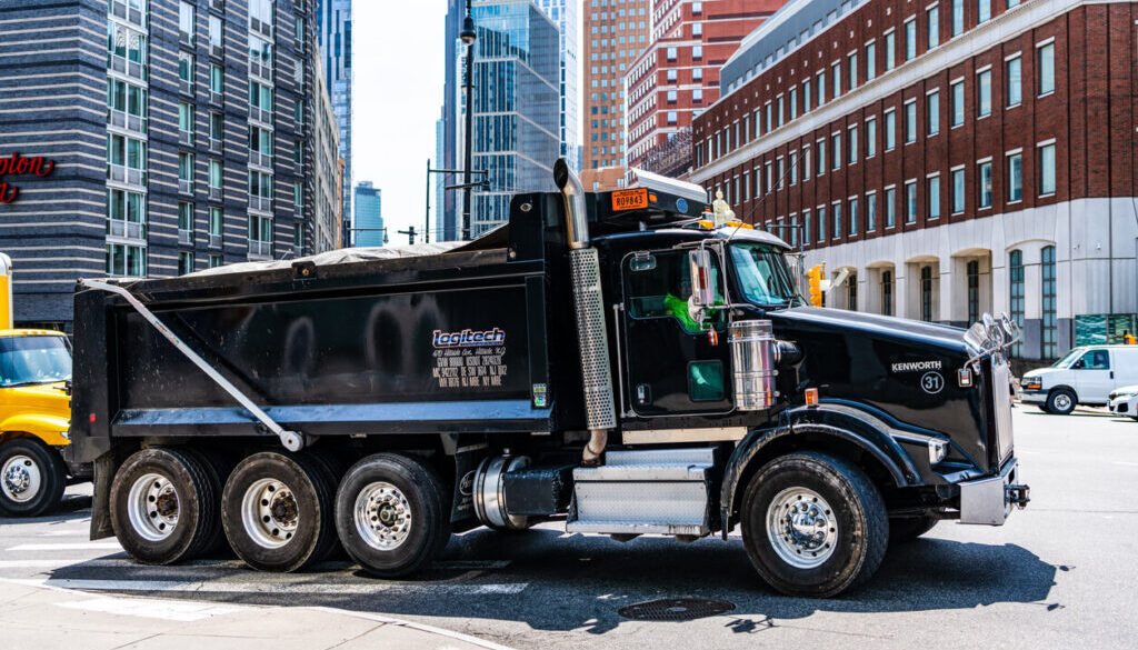 Black dump truck on city street