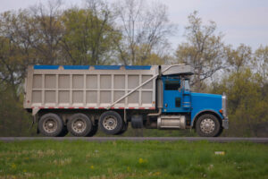 Blue dump truck driving on road