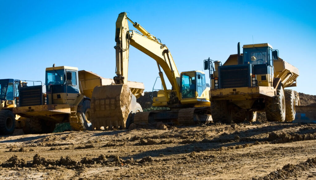 Construction vehicles on a dirt site. DOT safety regulations