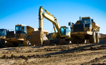 Construction vehicles on a dirt site. DOT safety regulations