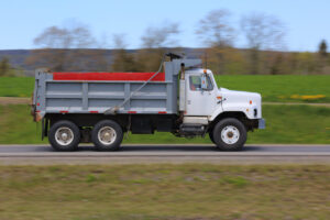 White and grey dump truck driving