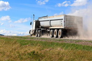 Truck driving on dusty gravel road
