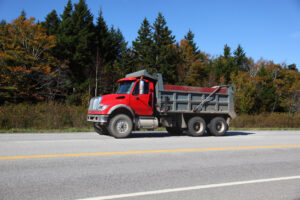 Red dump truck on roadside