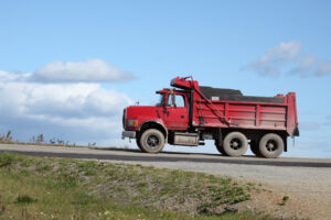 Red dump truck on gravel road