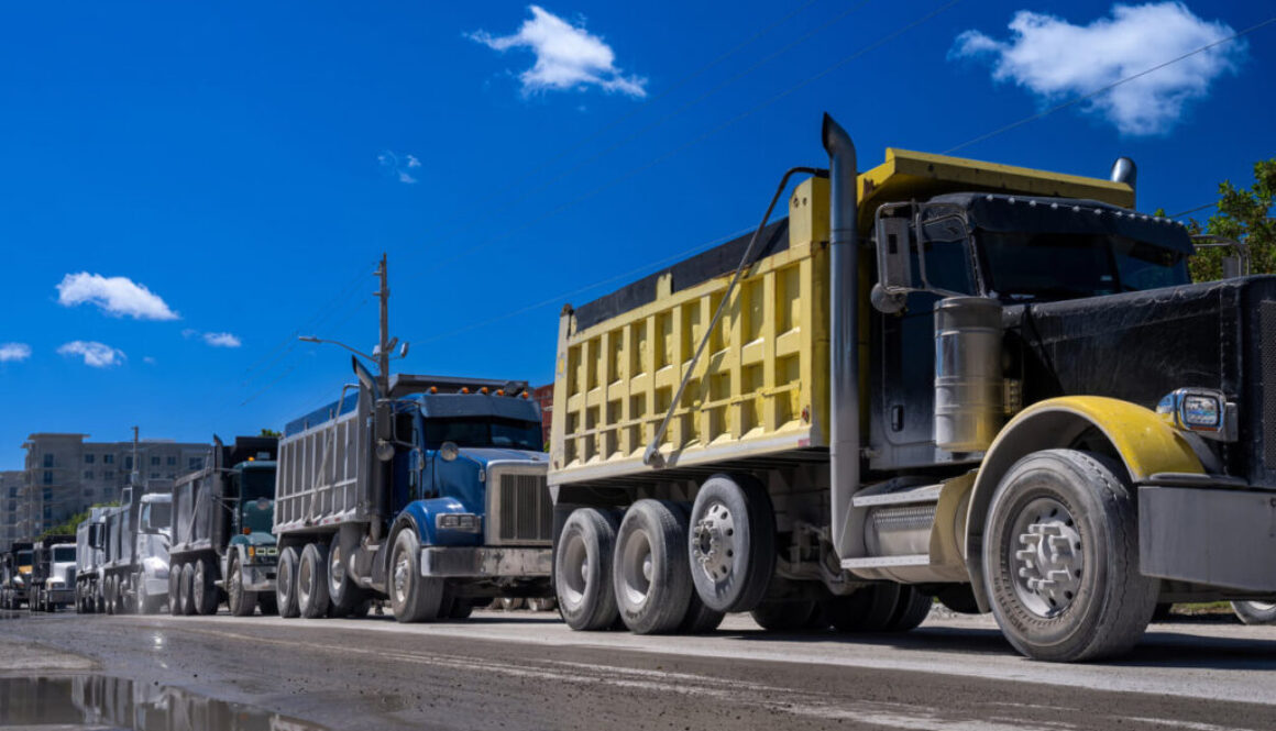 dump trucks lined up on road DOT