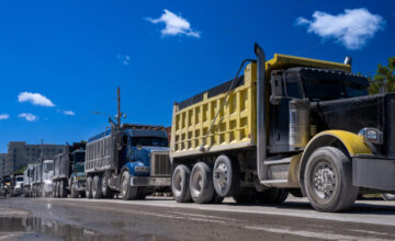 dump trucks lined up on road DOT