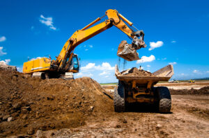 Excavator loading dirt into dump truck