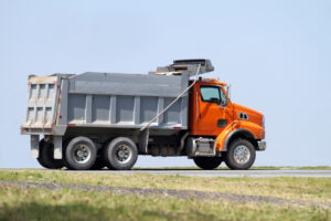 Orange dump truck on roadside