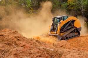 Compact Track Loaders vs Skid Steers for Contractors 2 Skid steer moving dirt and dust Red Wood Dust Skid Steer
