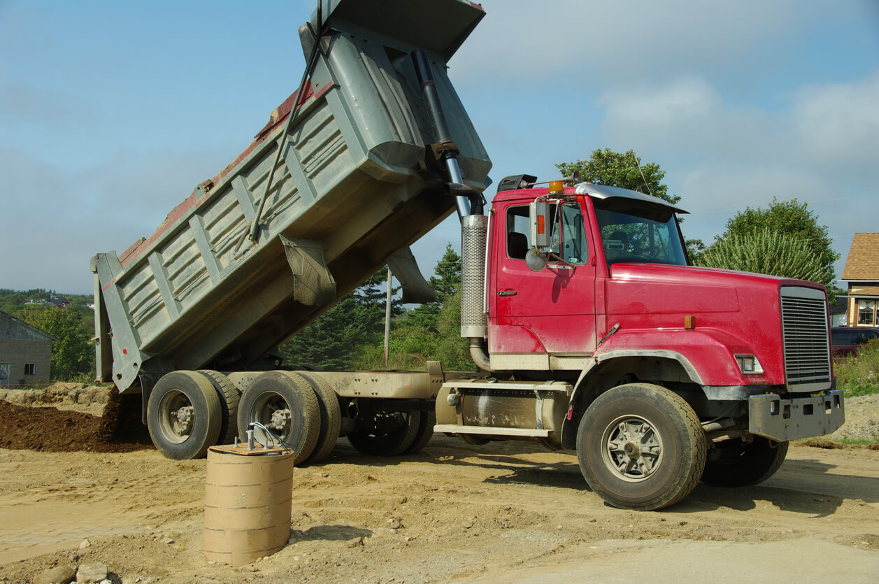 Dump Truck Weight Limits by State in 2026 2 Red dump truck unloading dirt