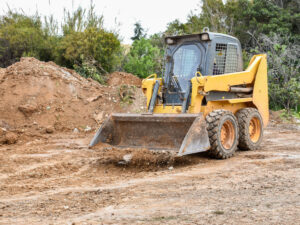 Yellow compact track loader on dirt
