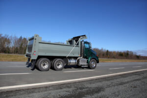 Green dump truck on the highway