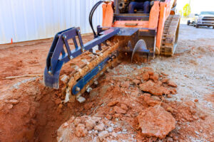 Top 22 Construction Equipment Types for Contractors 12 Trencher digging into the ground.
