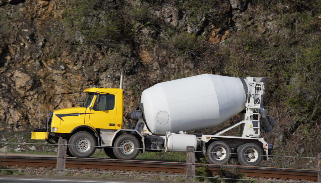 Yellow concrete mixer truck on road