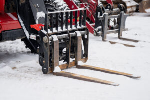 Top 5 Skid Steer Attachments for Contractors in 2026 5 Snow-covered skid steer pallet forks